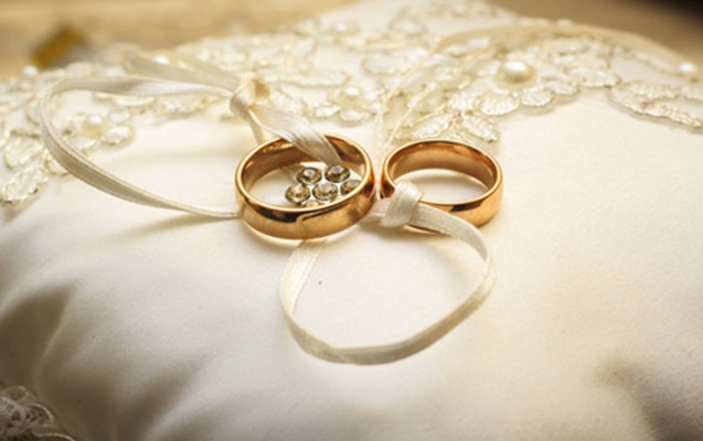 Close-up of wedding rings delicately placed on a blossoming branch, symbolizing the union and commitment celebrated at Panola Valley Gardens.